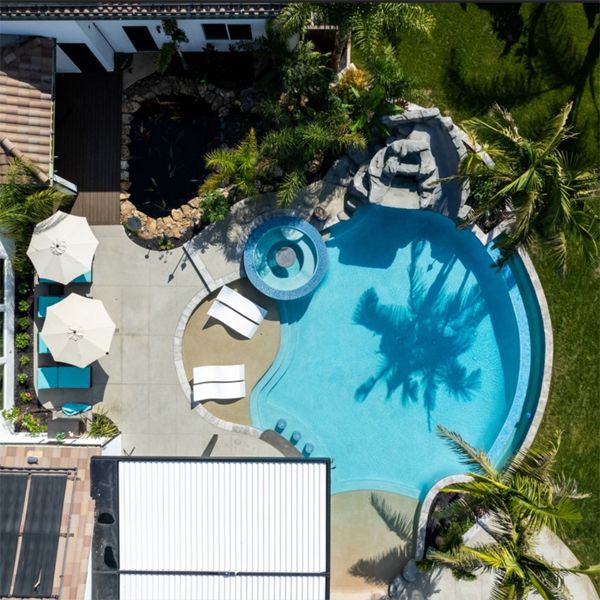 drone view of a private custom infinity pool with a built-in spa, by Majestic Pools and Spas