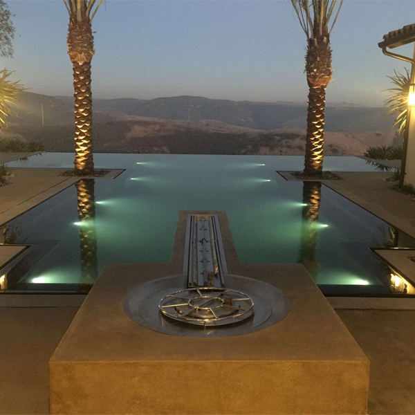 Outdoor living with infinity pool at sunset by Creative Atmospheres