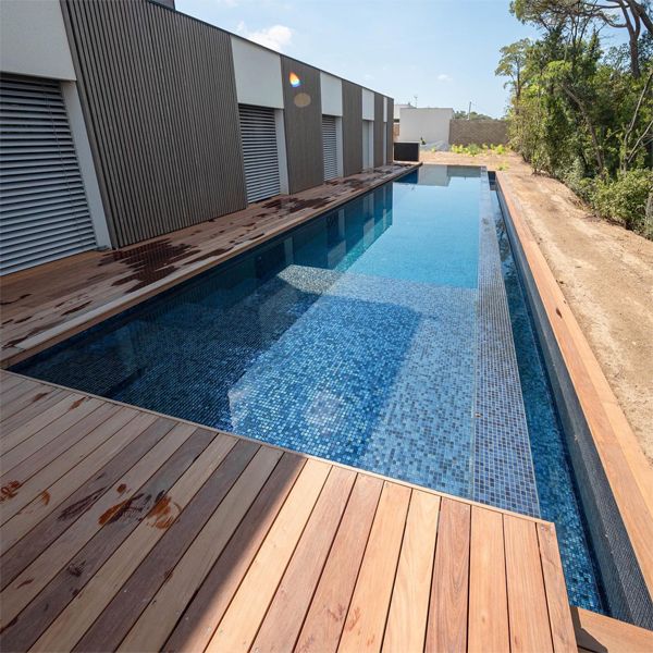 infinity lap pool by MCR Piscines and wooden decking