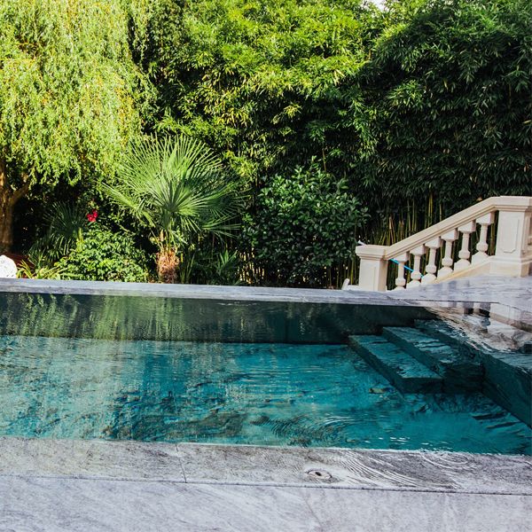 luxury steel overflow pool (mirror effect), with mobile bottom covered with marble, by Steel and Style