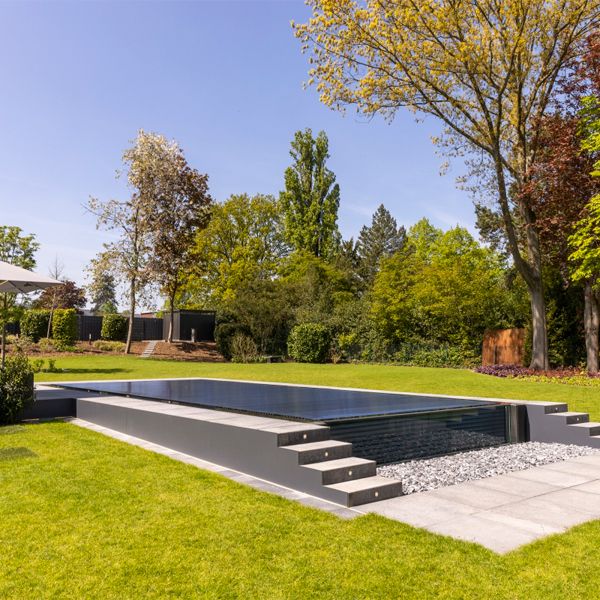 infinity pool with transparent wall an automatic pool cover, by Weidner Pools
