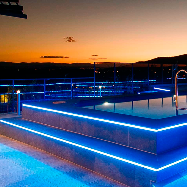 above ground lighted swimming pool at night by Leader Pools
