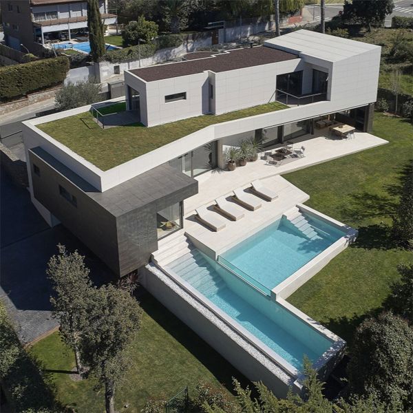 drone view of custom pool on two levels with a transparent wall in a project by GAAB Arquitectes