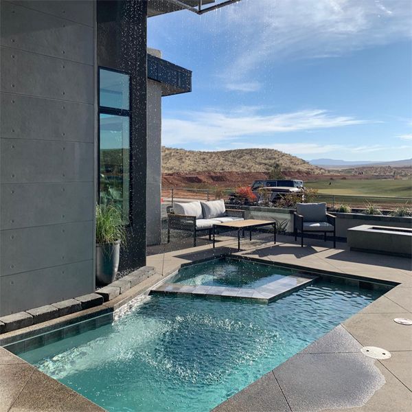 Custom mini pool with a built-in spa and a lamp shaped water feature, rain effect, by Cutting Edge Pools