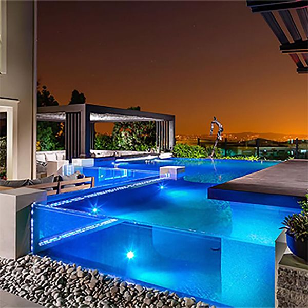 transparent infinity pool at night, by Splash Pools and Construction