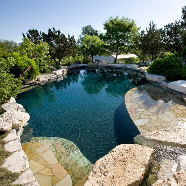 custom pool surrounded by stones and trees