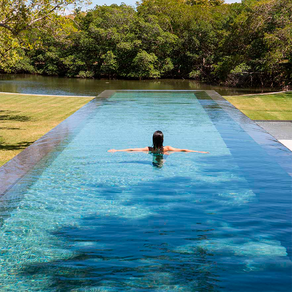 woman bathing in a infinity pool by Pool Tech of Miami