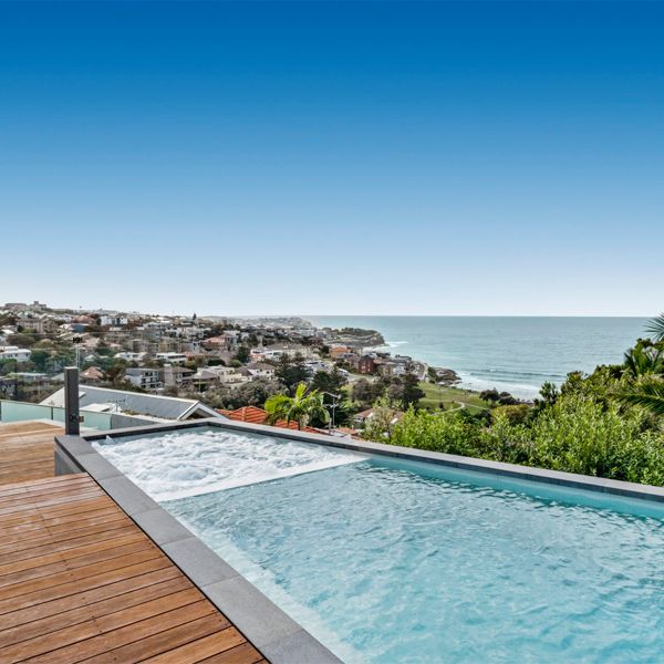 custom pool and built-in spa with sea view, by Trademark Pools