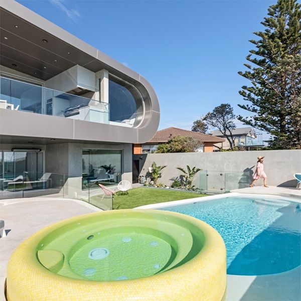 a unique custom pool with a yellow spa, by Enki Pools