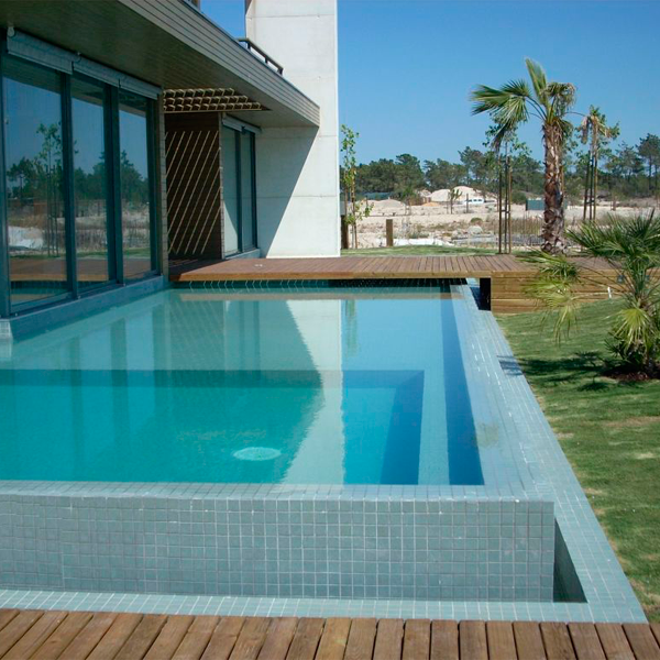 piscina exterior tipo infinity con revestimiento gresite azul