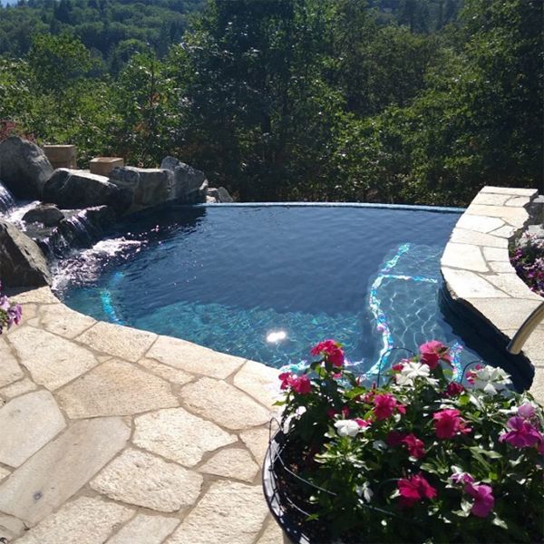 bespoke mini infinity pool, with waterfall over the rocks, by Sundance Pools