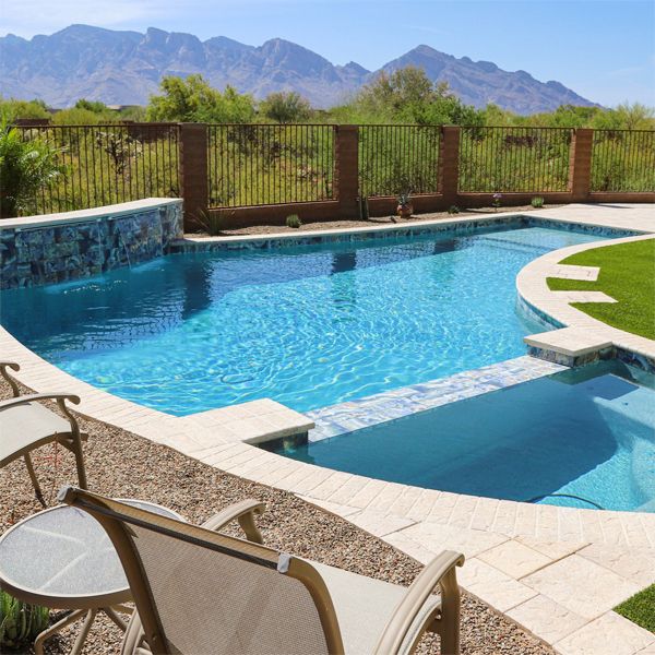 Curved L-shaped private pool and integrated spa, with a combination of continuous pebbletec and tile coating, by Soaz Pools