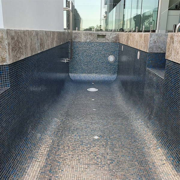 coating in porcelain stoneware and glass mosaic of an infinity pool by Adept Pools