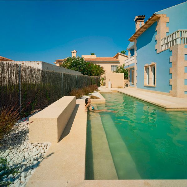 woman sitting on the edge of a l-shaped pool, in a proyect by Pepa Diaz Arquitecta