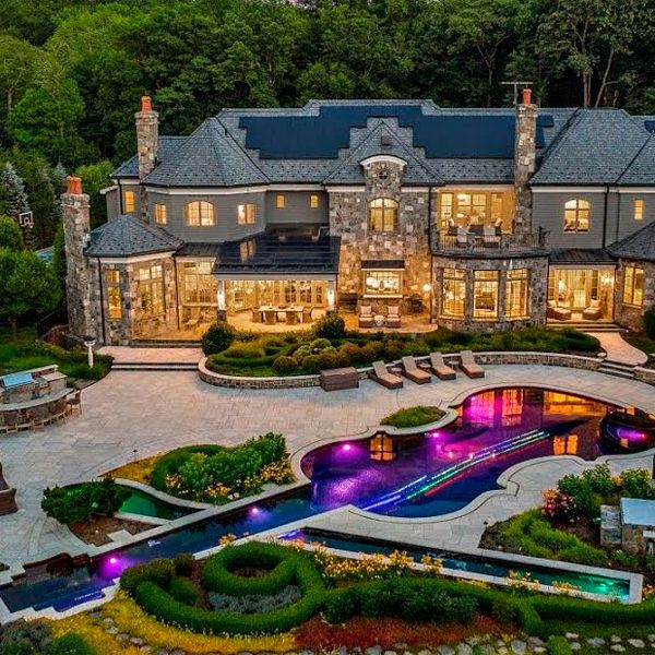 drone view of a unique pool and spa with a violin desin, at night, by Cipriano Landscape Design