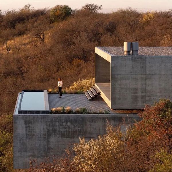 a woman on the terrace of a modern and minimalist house with an infinity pool, by Gaston Sironi Arquitectos