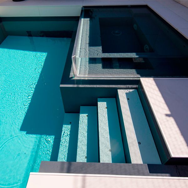 Transparent spa and interior ladder in custom movable bottom pool, by Mission Pools