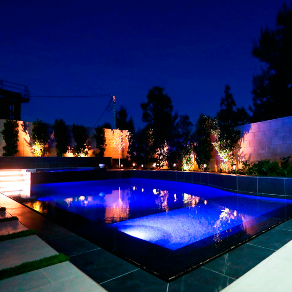 Conjunto piscina y spa negros con iluminacion nocturna