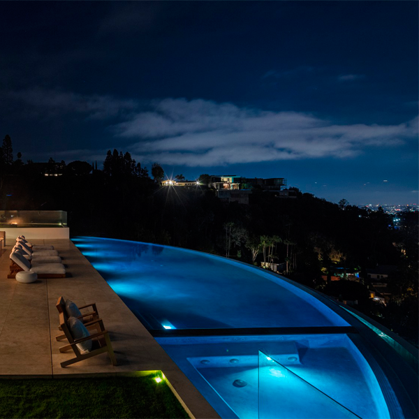 suspended round pool at night by McClean Design