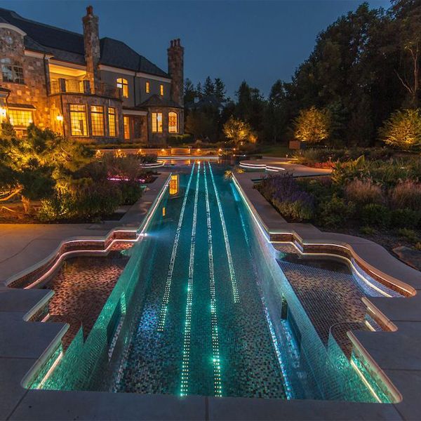 a unique pool and spa with a violin desin, at night, by Cipriano Landscape Design
