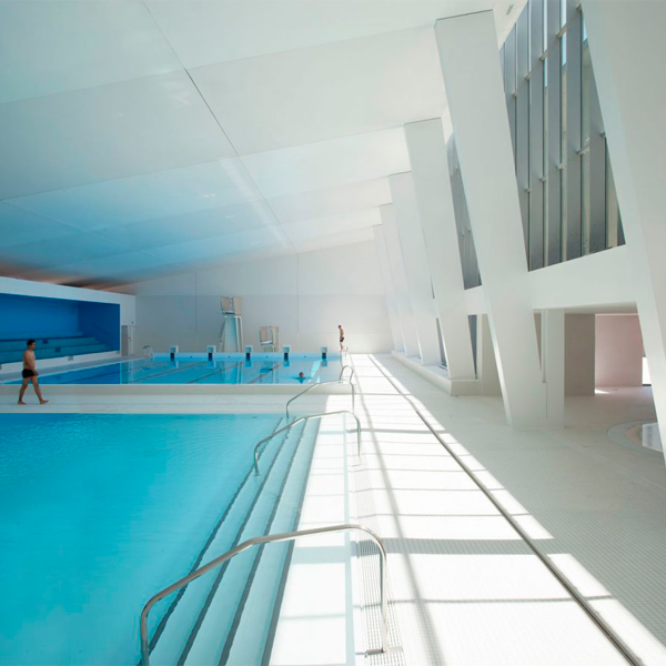 piscina publica interior con decoración blanca y azul