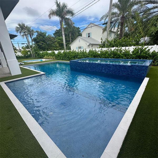 Custom geometric private pool with raised overflow spa, by Chief Pools Plastering
