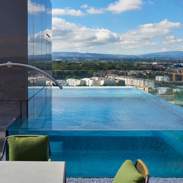 steel infinity pool with transparent walls built in a rooftop, by Nicollier Group