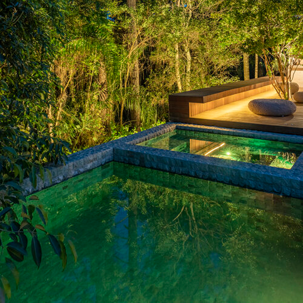 spa in a vacation villa pool at night by Macro Arquitetos