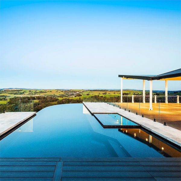 Custom infinity pool with built-in spa, by Esjay Landscapes, at sunset