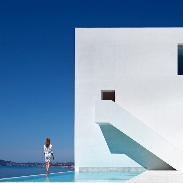 mujer de pie sobre borde infinito de piscina minimalista tipo infinity