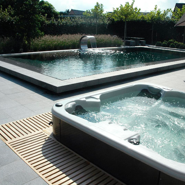 piscina desbordante tipo espejo en color oscuro con spa al lado