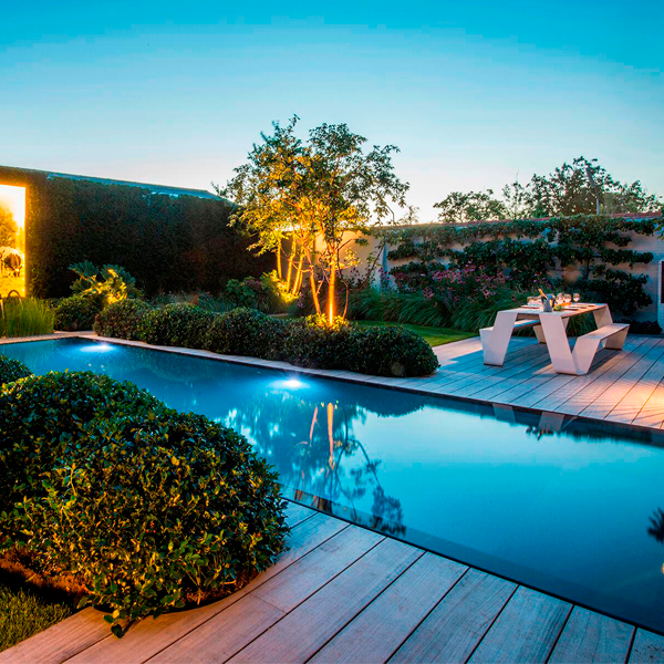 piscina desbordante con entorno en madera y vegetación
