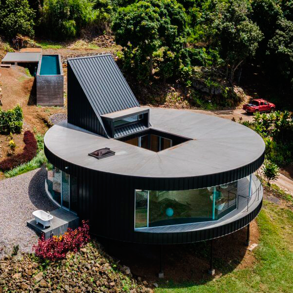 vista aérea de cas redonda con piscina rectangular elevada en hormigón