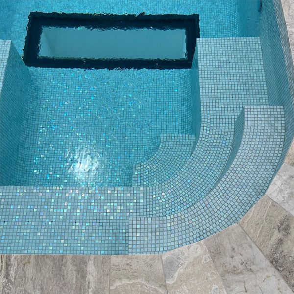 bright mosaic tile of a private custom pool with underwater windows in the floor, by Dreamscape Pools and Landscaping