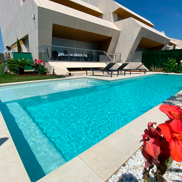 Elegante piscina tonos claros junto a chalet
