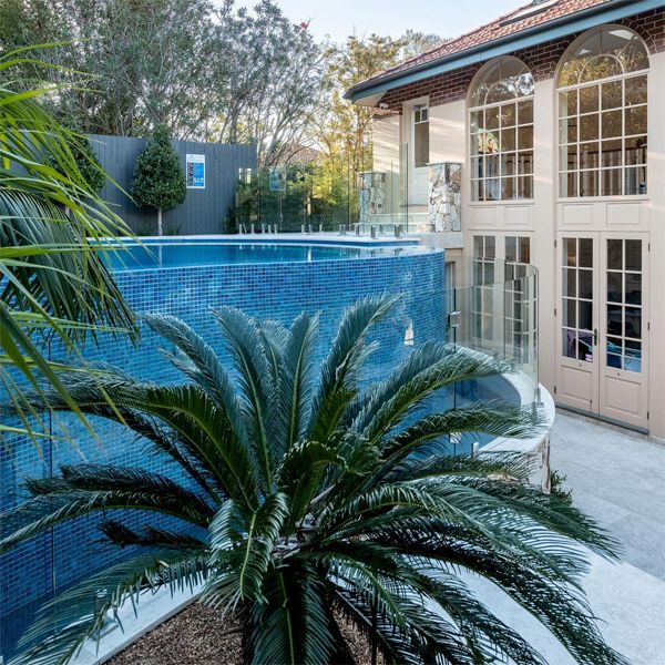 Above ground custom infinity pool by Fluid Design, seen from the backyard