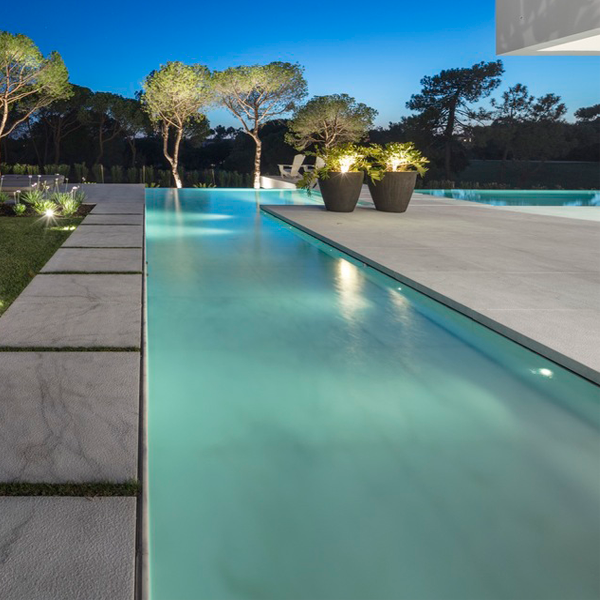 private overflow pool and landscaping at night by Visioarq