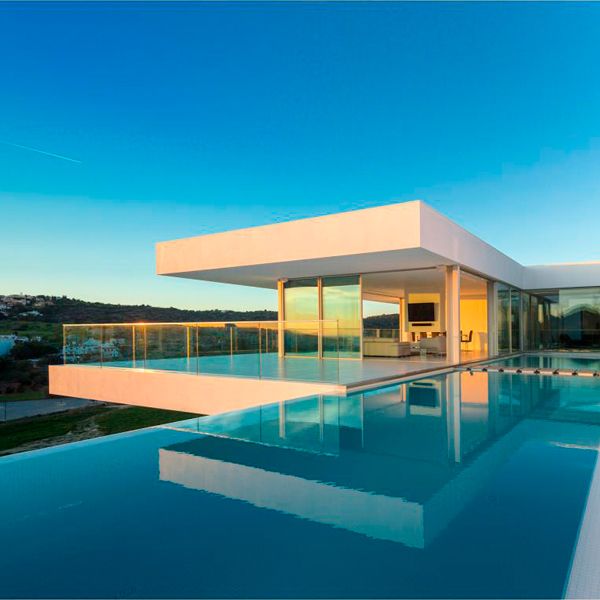 white infinity lap pool at sunset, in a project by Mario Martins Atelier