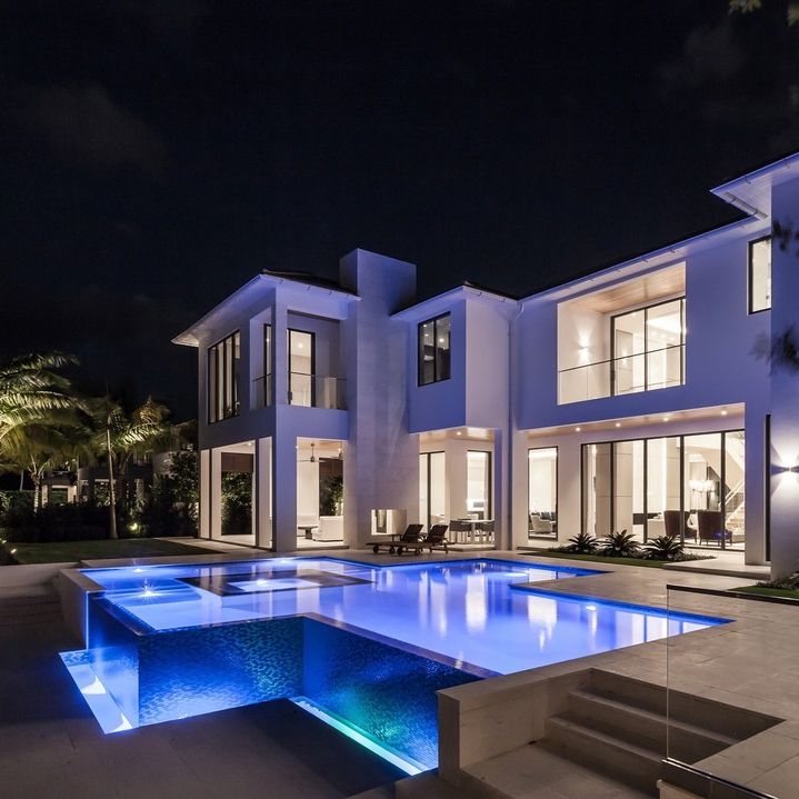 Luxury infinity pool with a custom design, based on straight lines, illuminated at night in a modern design house, by Mothe Design.