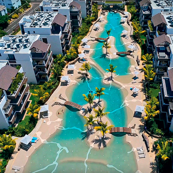 Enorme piscina tipo playa en el centro de un complejo de apartamentos