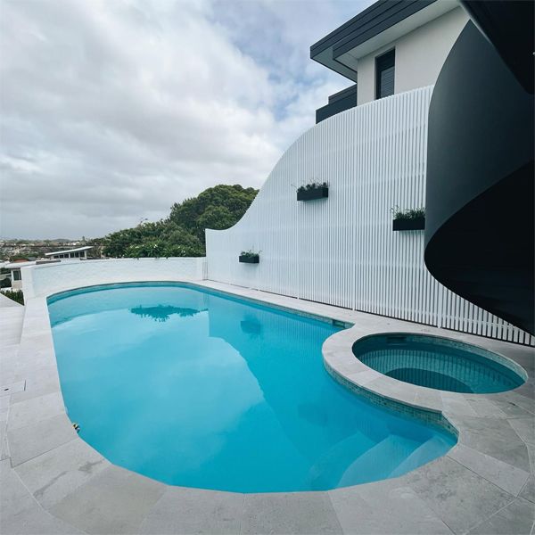 Custom rounded swimming pool and spa in the small backyard of a modern design house, by Evantage Building