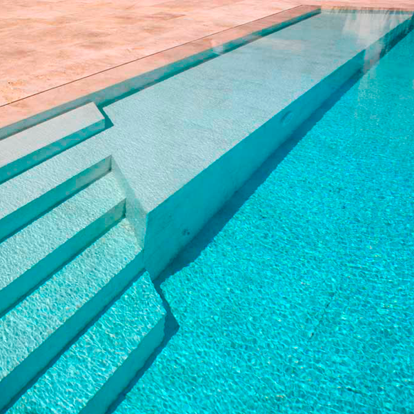 piscina desbordante con travertino
