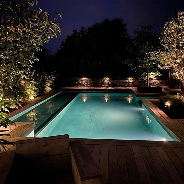 custom natural pool at night, by Messner Gaerten