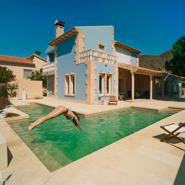 woman diving into a l-shaped pool, in a proyect by Pepa Diaz Arquitecta
