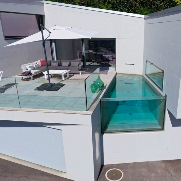 Minipiscina transparente en un chalet unifamiliar instalada entre paredes