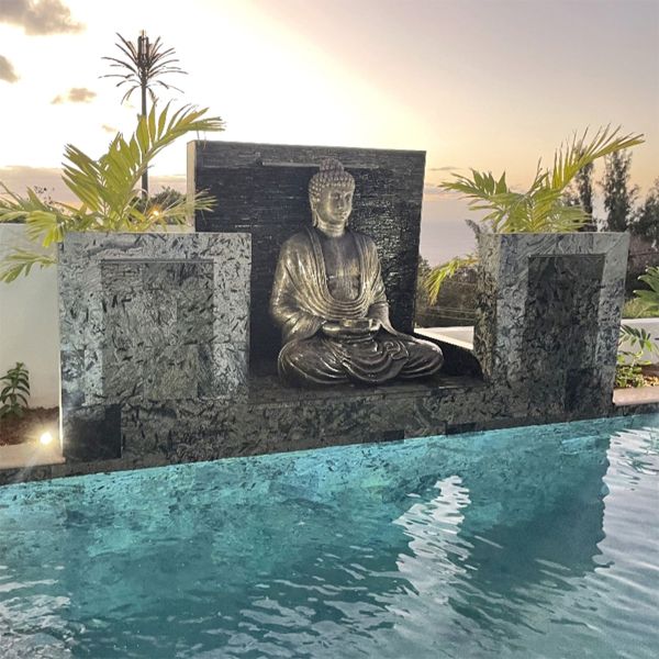 Private mini pool with a Zen design and natural stone cladding, by Sarana Pools, decorated with waterfalls and a figure of Buddha.