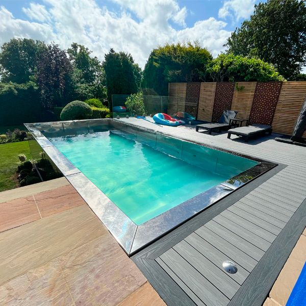 stainless steel pool rounded by synthetic wooden deck, in a landscaping project by Raze Roberts