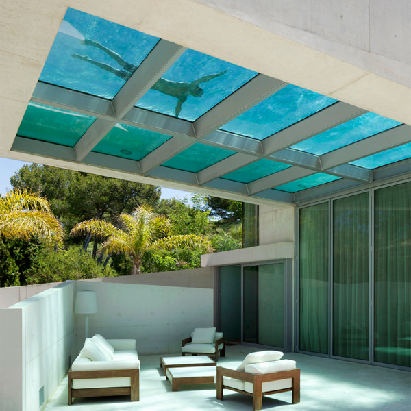 persona flotando en piscina con suelo transparente