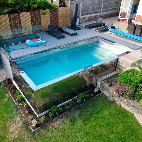 drone view of a stainless steel pool rounded by synthetic wooden deck, in a landscaping project by Raze Roberts