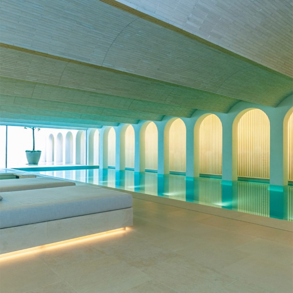 picina interior con zona spa y arcos decorativos en las paredes